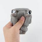 Stone man releases stress toy slowly rebounds soft Moai statue squeeze eyes interested expression relaxes stress children's gift